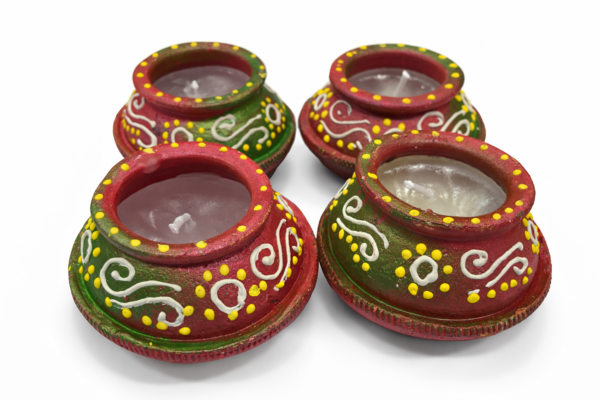 Green and red earthen matki diyas with wax