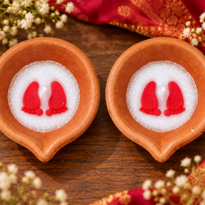 Styled visualization of two matching mitti diyas with red auspicious charan motifs, set of two
